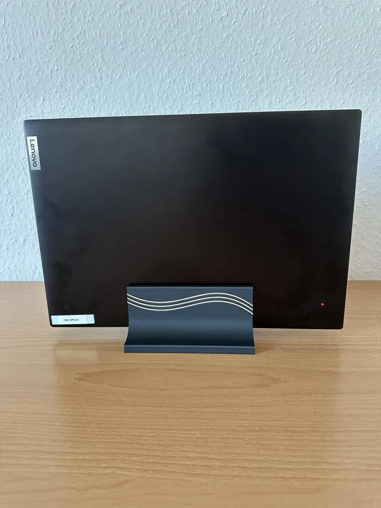 Black 3D printed vertical laptop stand holding a laptop upright, front view