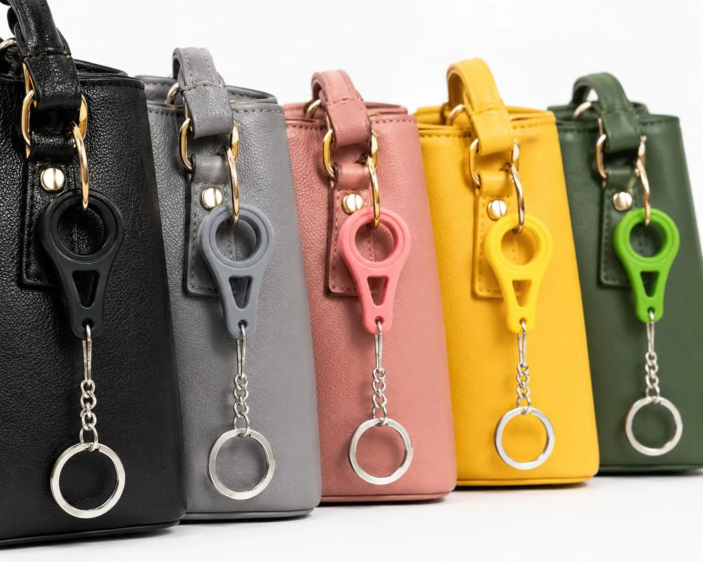 Bag clip keychains in black, grey, pink, yellow and green on matching handbags