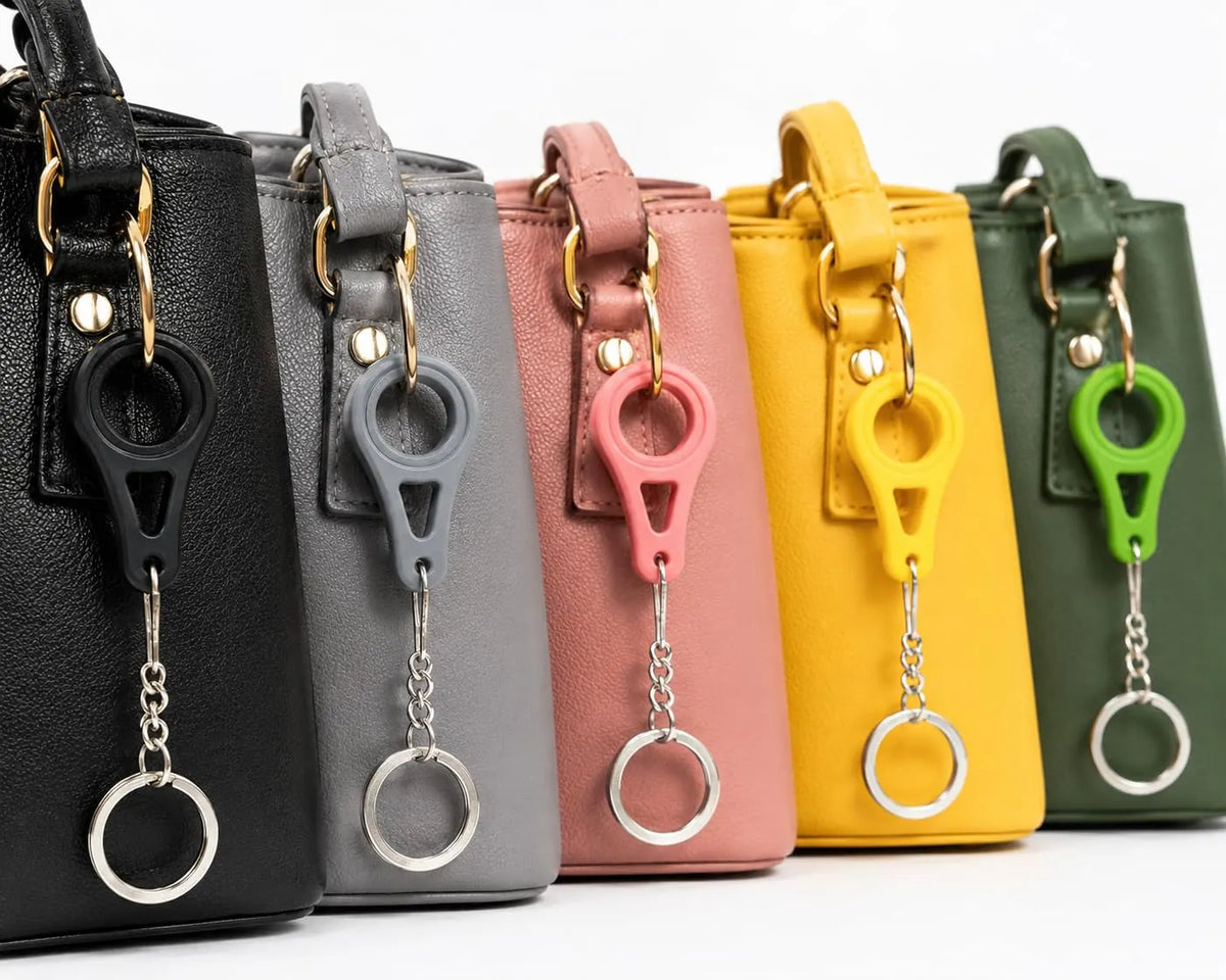 Bag clip keychains in black, grey, pink, yellow and green on matching handbags