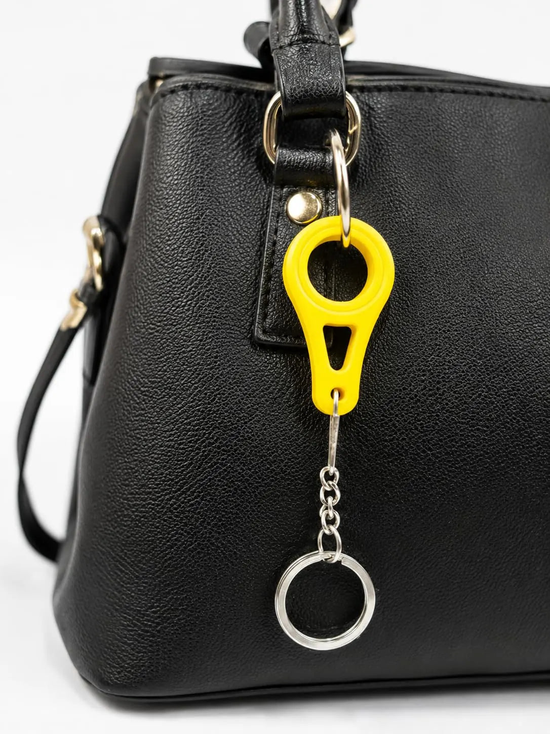 Yellow bag clip keychain hooked onto a black handbag