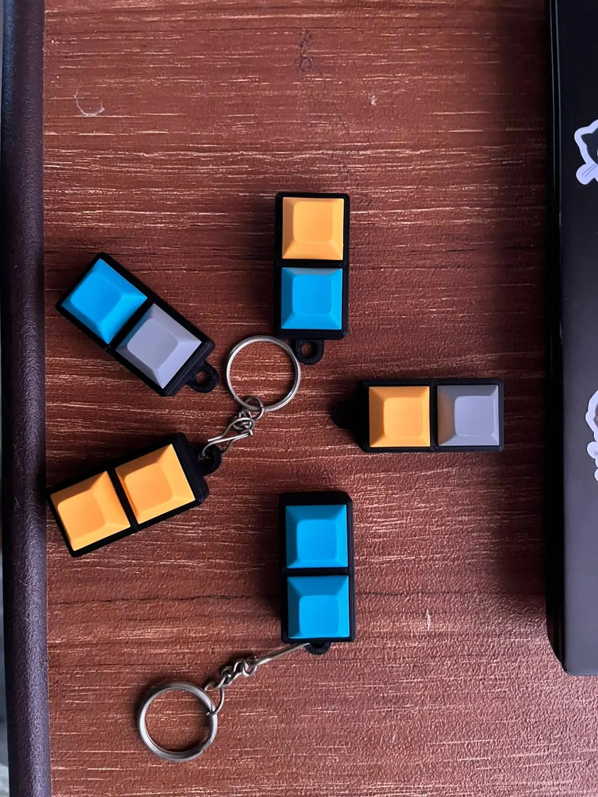 2-key mechanical keychains in assorted colours on a wooden table